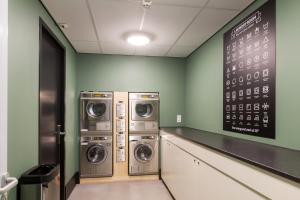 a laund room with three washing machines and a chalkboard at Hotel2Stay in Amsterdam