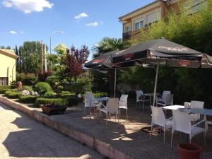 a patio with tables and chairs and an umbrella at Arcas de Agua in Arcas