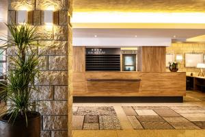 eine Lobby eines Restaurants mit zwei Topfpflanzen in der Unterkunft Hotel Haliaetum - San Simon Resort in Izola