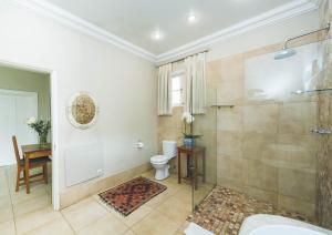 a bathroom with a toilet, sink, and bathtub at Osborne House in Pretoria