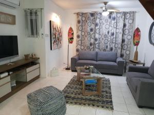 sala de estar con 2 sofás y TV en Villa Bienvenue Beachfront House en Flic-en-Flac