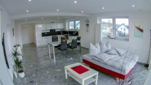 ein Wohnzimmer mit einem Sofa und einem Tisch sowie eine Küche in der Unterkunft Ferienwohnung Klara in Kißlegg