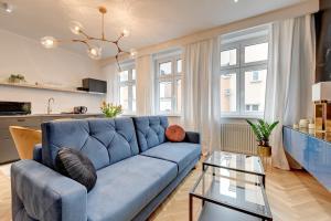 a living room with a blue couch and a table at Dom & House - Apartments Old Town Powroznicza in Gdańsk