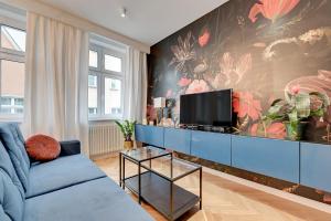 a living room with a blue couch and a tv at Dom & House - Apartments Old Town Powroznicza in Gdańsk