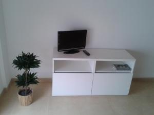 uma secretária branca com uma televisão por cima em Apartments Sorrabona em Pineda de Mar