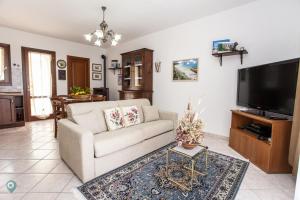 a living room with a couch and a flat screen tv at Villino Bordeaux in San Teodoro