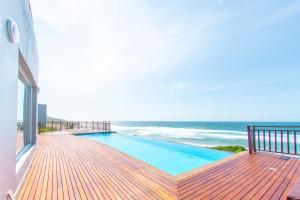 balcón con piscina y océano en Residence on Sea View, en Tinley Manor