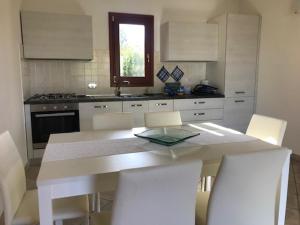 een keuken met een tafel en stoelen in een keuken bij Corallo in San Teodoro