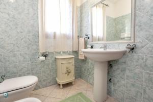 a bathroom with a sink and a toilet and a mirror at Villino Bordeaux in San Teodoro +26 photos
