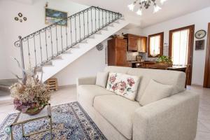 a living room with a couch and a staircase at Villino Bordeaux in San Teodoro