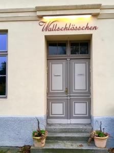 una porta di un edificio con due vasi di Apartment Schloss Benrath a Greifswald