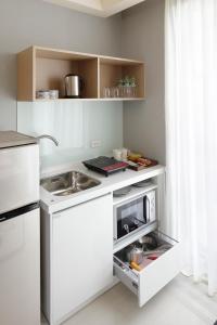 a white kitchen with a sink and a microwave at Jolley Hotel in Taipei