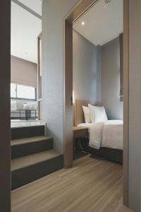 a bedroom with a bed and stairs leading to a room at Jolley Hotel in Taipei