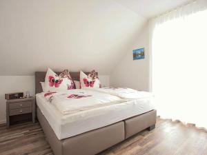 a bedroom with a large white bed with pink pillows at Ferienhaus am Rösslewald in Breitnau