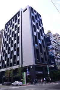 een groot zwart-wit gebouw in een stadsstraat bij Jolley Hotel in Taipei