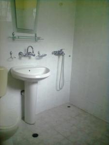 a white bathroom with a sink and a shower at Oasis Villas in Golden Sands