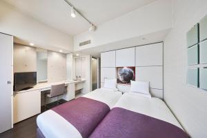 a bedroom with a large bed and a desk at HOTEL MYSTAYS Shimizu in Shizuoka