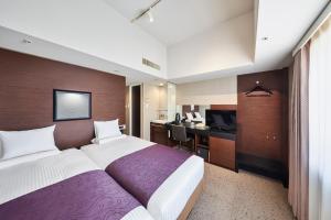 a hotel room with a large bed and a desk at HOTEL MYSTAYS Shimizu in Shizuoka