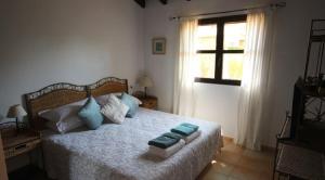 Un dormitorio con una cama con almohadas azules y una ventana en HL036 · HL 036 Luxury 3 bedroom villa , high standard, en Fuente Alamo