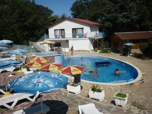 a pool with umbrellas and people swimming in it at Oasis Villas in Golden Sands