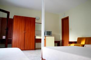 a bedroom with a bed and a cabinet and a television at Oasis Villas in Golden Sands