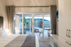 a bedroom with a bed and a view of a patio at CM34 - Pezula Heaven On Earth in Knysna