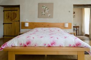 a bedroom with a large bed with a pink comforter at Cocon des Cévennes in Saint-André-de-Valborgne