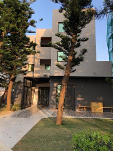 a building with a pine tree in front of it at Araucaria Residence in Huxi