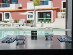 a table with two wine glasses and napkins on it at Topazio Vibe Beach Hotel & Apartments - Adults Friendly in Albufeira
