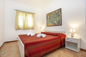 a bedroom with a bed and a painting on the wall at Villino Funtana Bilo in San Teodoro