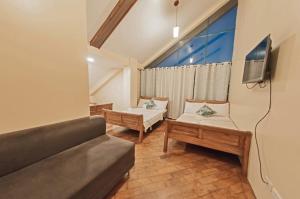 - un salon avec un canapé et une télévision dans l'établissement The Half House by Elmar Cabin, à Baguio