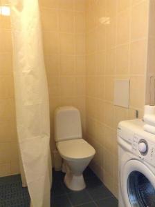 een badkamer met een toilet en een wasmachine bij Wilde Guest Apartments Ülikooli 6 in Tartu