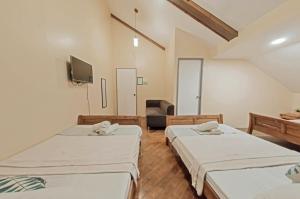 um quarto de hospital com duas camas e uma televisão em The Half House by Elmar Cabin em Baguio