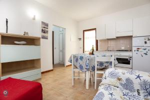 a kitchen with a table with chairs and a kitchen with a counter at Villino Funtana Bilo in San Teodoro