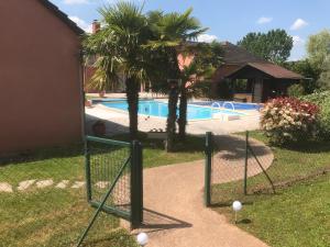 uma cerca com bolas de golfe em frente a uma piscina em Chambres d'Hôtes La Coloniale em Varetz