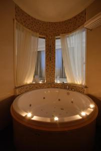 a bath tub with lights in front of a window at Batumi World Palace in Batumi