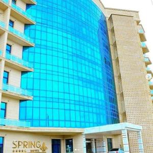 a large blue glass building in front of a building at Spring Hotel in Novxanı