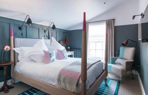 a bedroom with a bed and a chair at The Swan Hotel in Southwold
