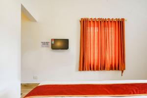a bedroom with an orange curtain on a wall at Wild Mist Homestay in Munnar