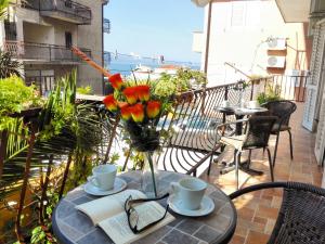a table with a vase of flowers and a book at Apartmani Buljubašić in Baška Voda