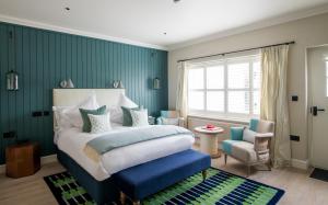 a bedroom with a bed and a blue wall at The Swan Hotel in Southwold