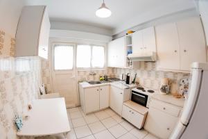 a small kitchen with white cabinets and a sink at Flisvos Seafront-Marina apartment in Athens