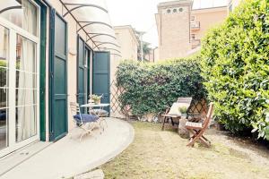 un patio con sedie e tavolo e un edificio di Bologna Garden House a Bologna