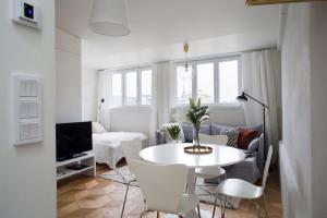 a white living room with a white table and chairs at 2ndhomes Ullanlinna Penthouse Apartments in Helsinki