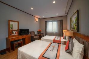 Hanoi Larosa Hotel في هانوي: غرفه فندقيه سريرين وتلفزيون