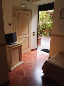 Zimmer mit einer Tür und einem TV auf dem Tisch in der Unterkunft Hotel Villa San Pio in Rom