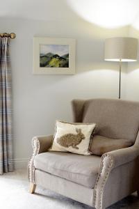 a chair with a pillow with a stuffed animal on it at Cotswold Grey in Moreton in Marsh