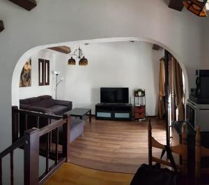 Una sala de estar con un sofá y un televisor. en Lovely 2 bedroom house with private garden, en Mogán