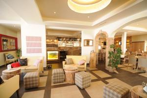 - un hall avec des canapés, des chaises et une cheminée dans l'établissement Hotel Restaurant FIDI, à Wolfsthal