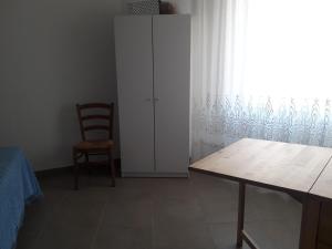 a room with a table and a chair and a white cabinet at casa maria in Sestri Levante